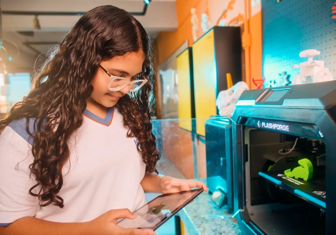Aluna operando impressora 3D no Espaço Maker